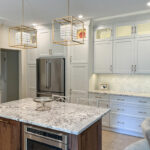 White painted kitchen perimeter cabinets and walnut natural island.