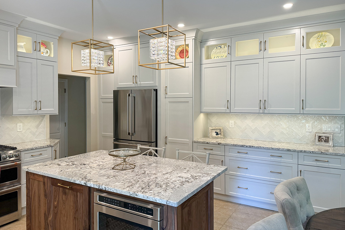 White painted kitchen perimeter cabinets and walnut natural island.