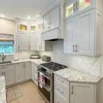 White painted kitchen perimeter cabinets and walnut natural island.