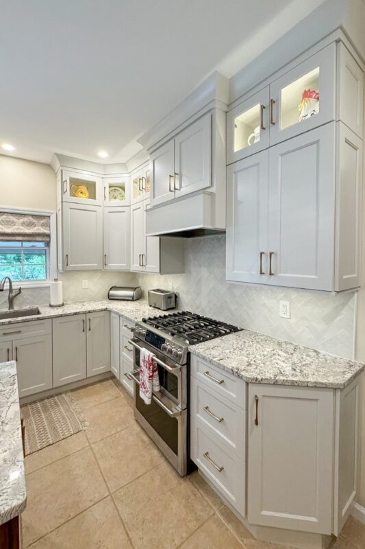 White painted kitchen perimeter cabinets and walnut natural island.