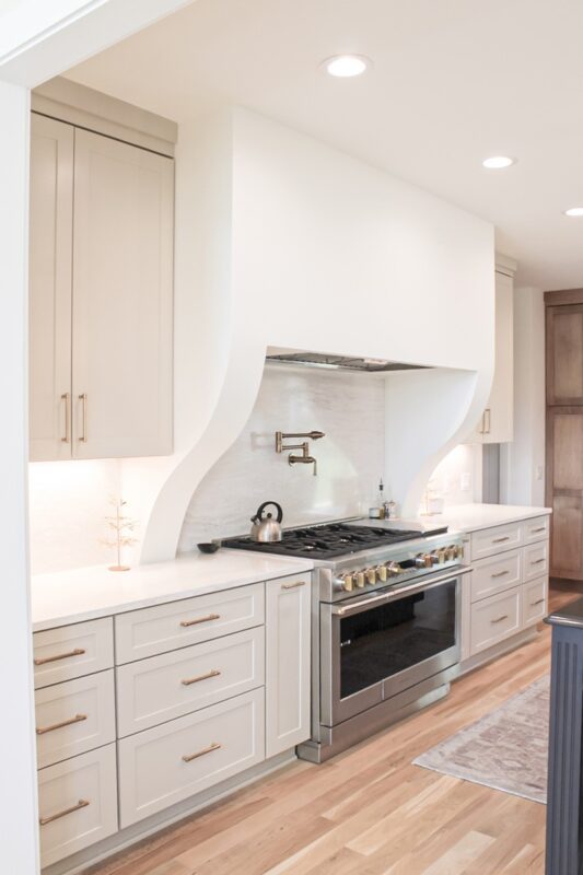 White painted cabinets and hood above stove