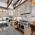 Light stained kitchen cabinets with exposed beams