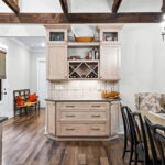 Light stained kitchen cabinets with exposed beams