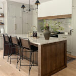 Small painted kitchen. Cabinets in light gray paint. Box hood painted white with stained brown accent that matches the stained island.