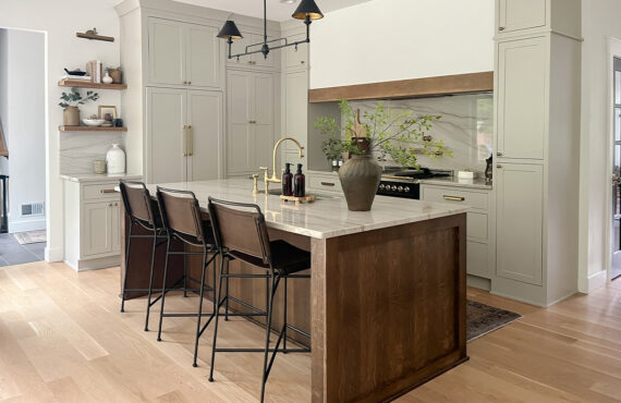 Small painted kitchen. Cabinets in light gray paint. Box hood painted white with stained brown accent that matches the stained island.