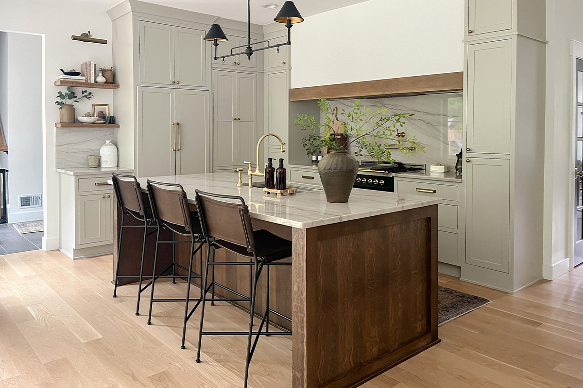 Small painted kitchen. Cabinets in light gray paint. Box hood painted white with stained brown accent that matches the stained island.
