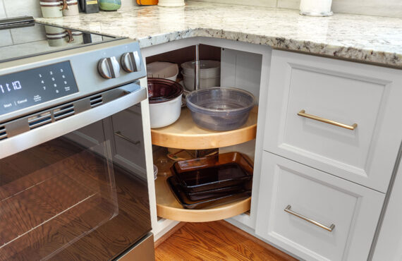 White painted kitchen cabinets with doors and drawers open to show internal storage accessories.