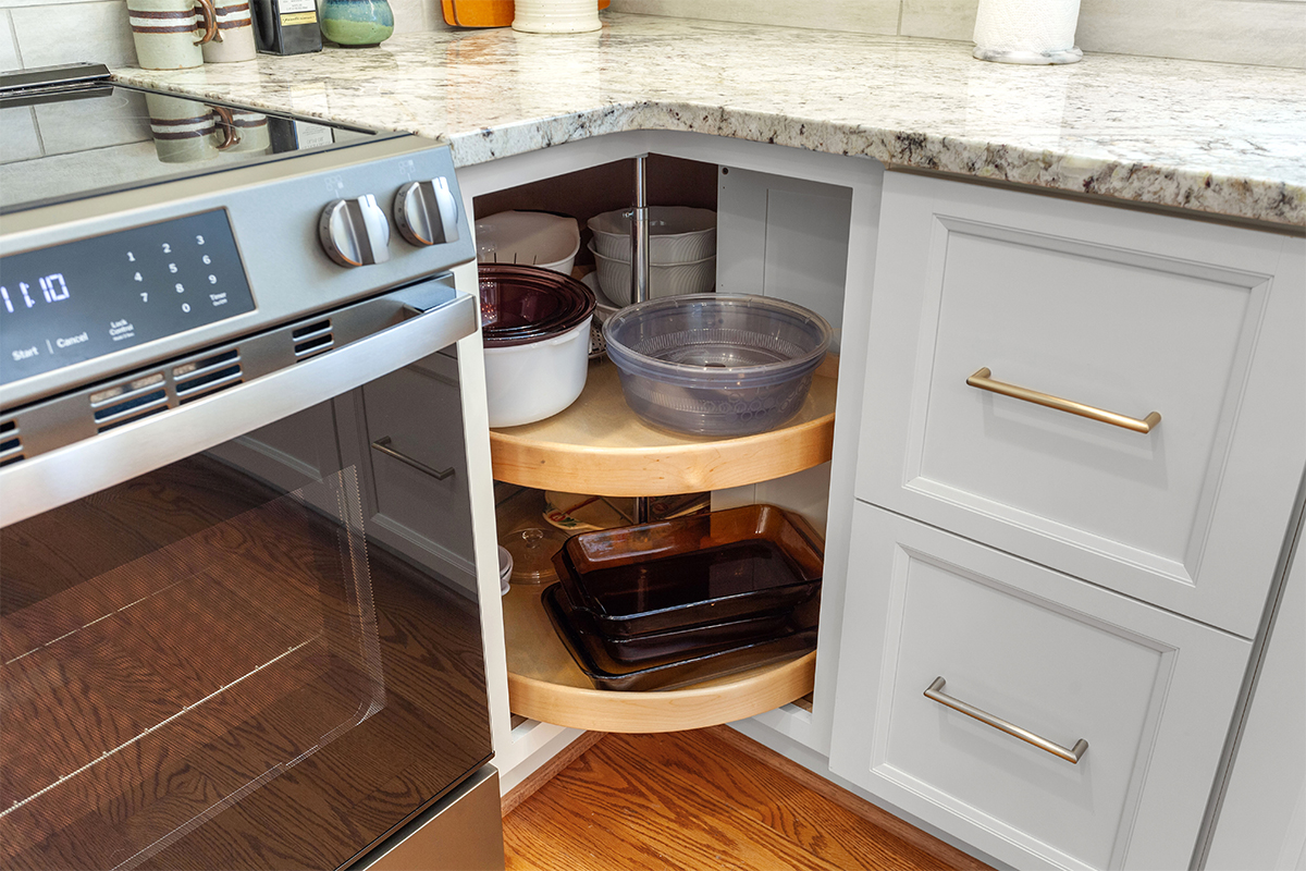 White painted kitchen cabinets with doors and drawers open to show internal storage accessories.