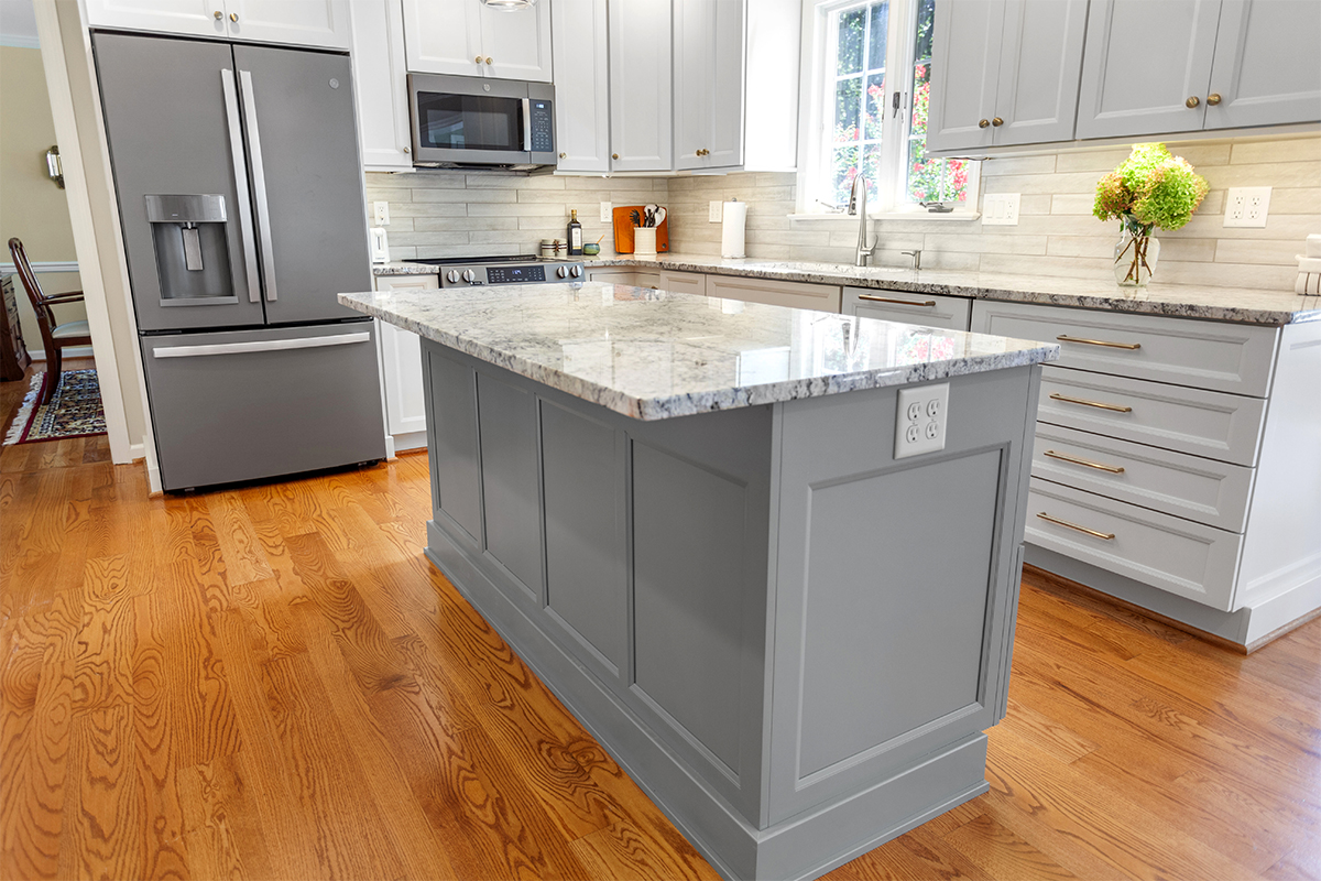 White-painted kitchen perimeter cabinets with a gray-painted island.