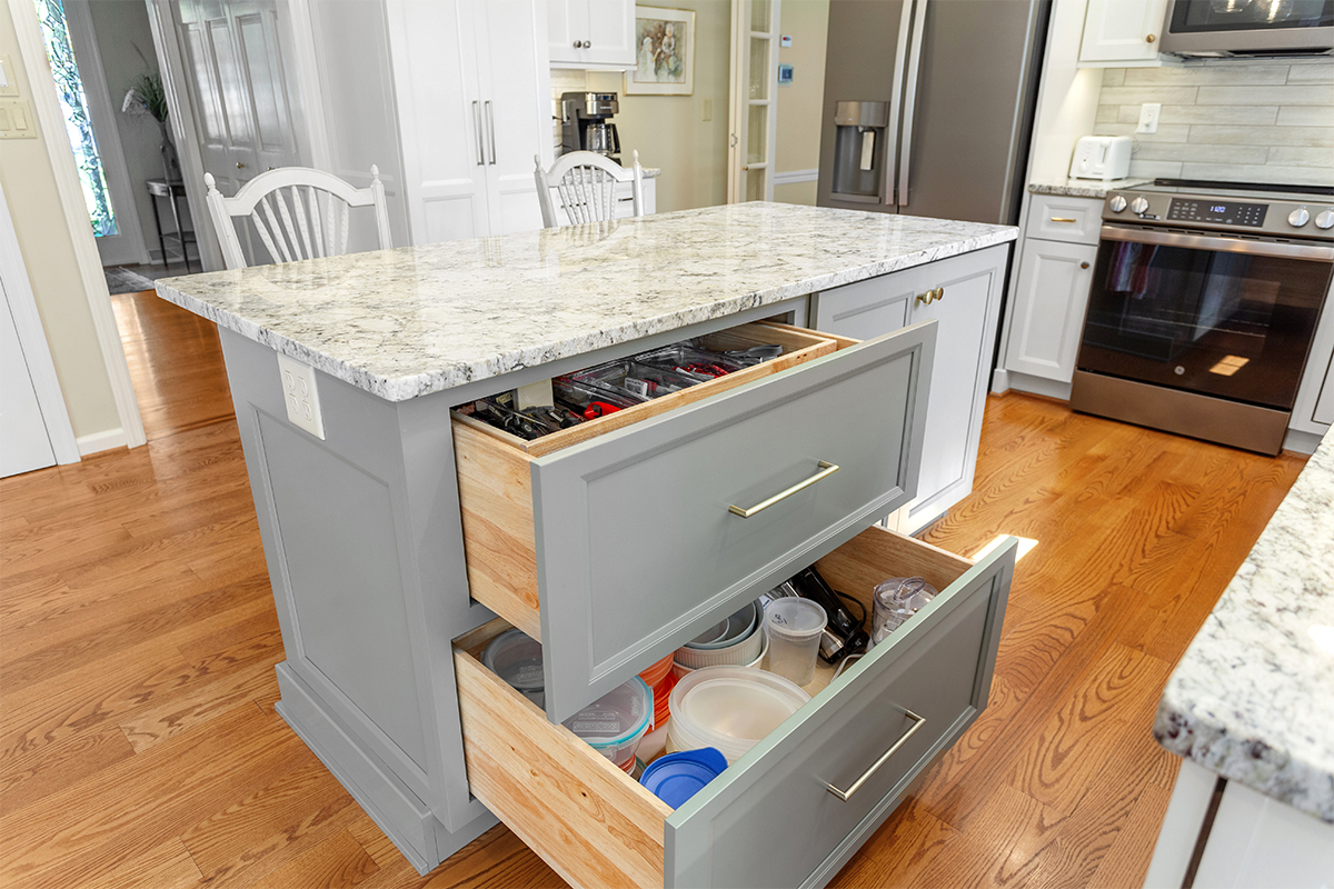 White-painted kitchen perimeter cabinets with a gray-painted island.