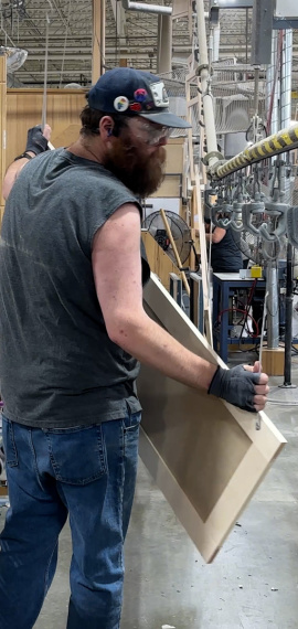 Man hanging a door on a paint conveyer line