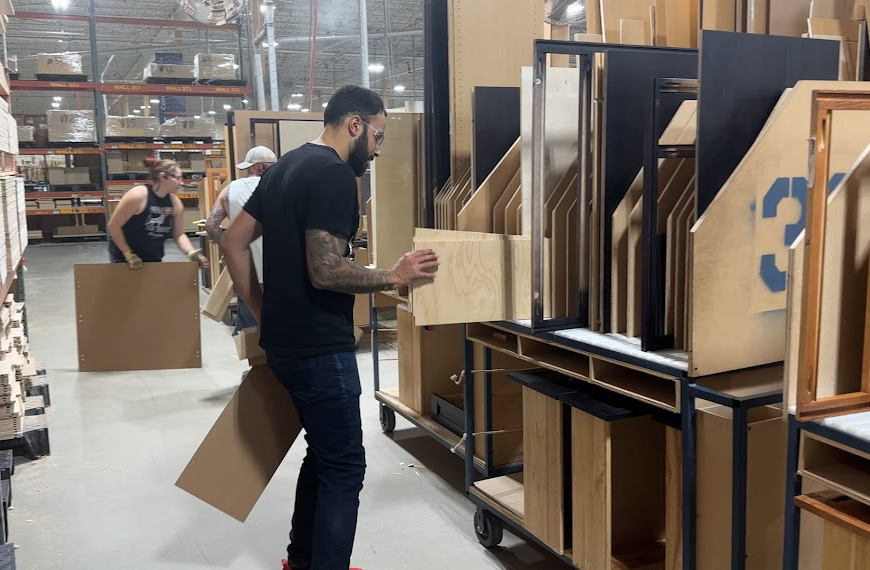 People pulling cabinet parts and placing no carts