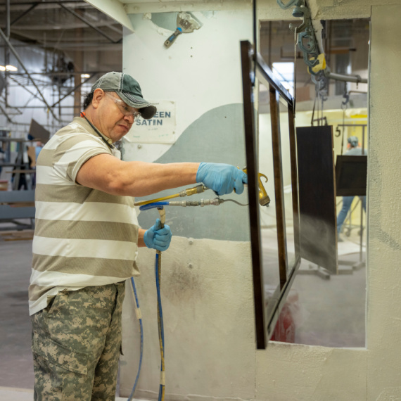 Man spraying finish in a booth