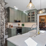 Painted green kitchen cabinets with unique wallpaper