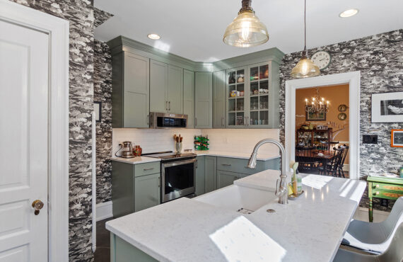 Painted green kitchen cabinets with unique wallpaper