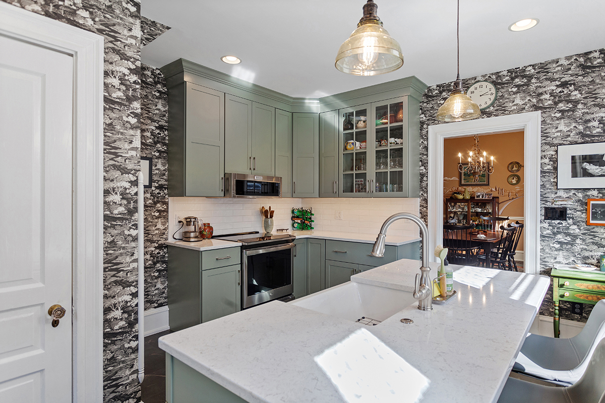 Painted green kitchen cabinets with unique wallpaper