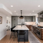 Painted gray and stained brown kitchen cabinets.