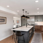 Painted gray and stained brown kitchen cabinets.
