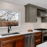 Painted gray and stained brown kitchen cabinets.