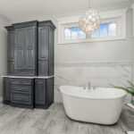 Painted bathroom cabinet with white stand-alone tub.