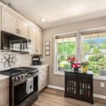 Light stained kitchen cabinets with black appliances.