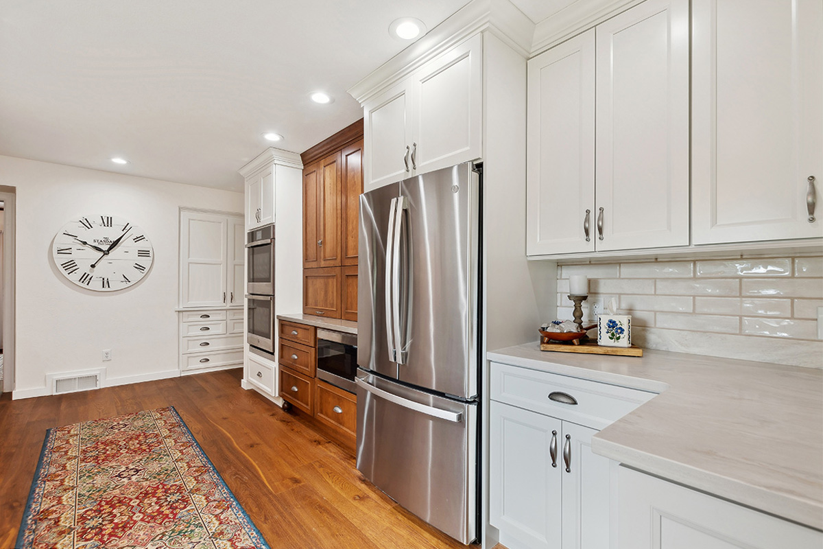 White kitchen with brown stained accent cabinets
