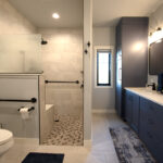 Bathroom with walk-in shower and vanity cabinets painted in Hale Navy color.