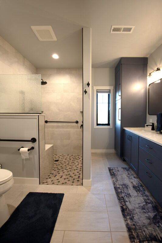 Bathroom with walk-in shower and vanity cabinets painted in Hale Navy color.