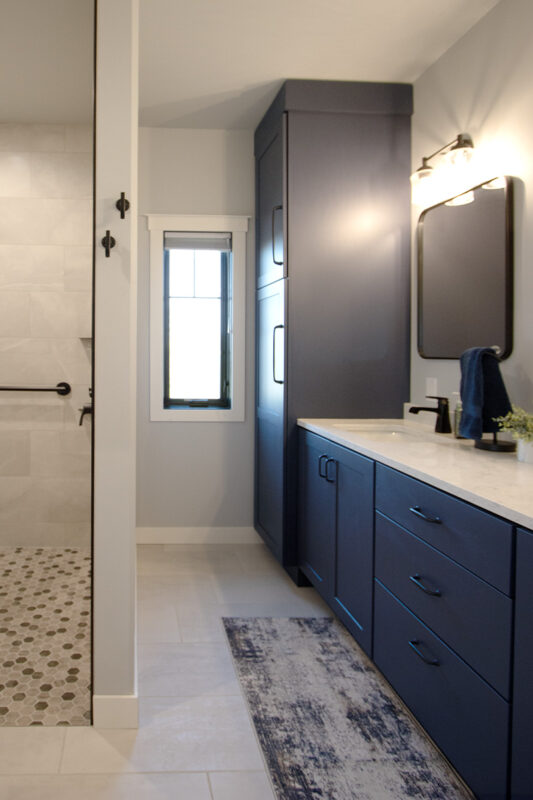 Bathroom with walk-in shower and vanity cabinets painted in Hale Navy color.