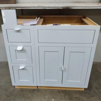 Base cabinets in a warehouse setting that are painted in a light blue "Upward" paint.