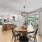 Dining room looking towards a white kitchen with light brown stained island.