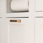 White painted kitchen cabinet with paper towel holder accessory