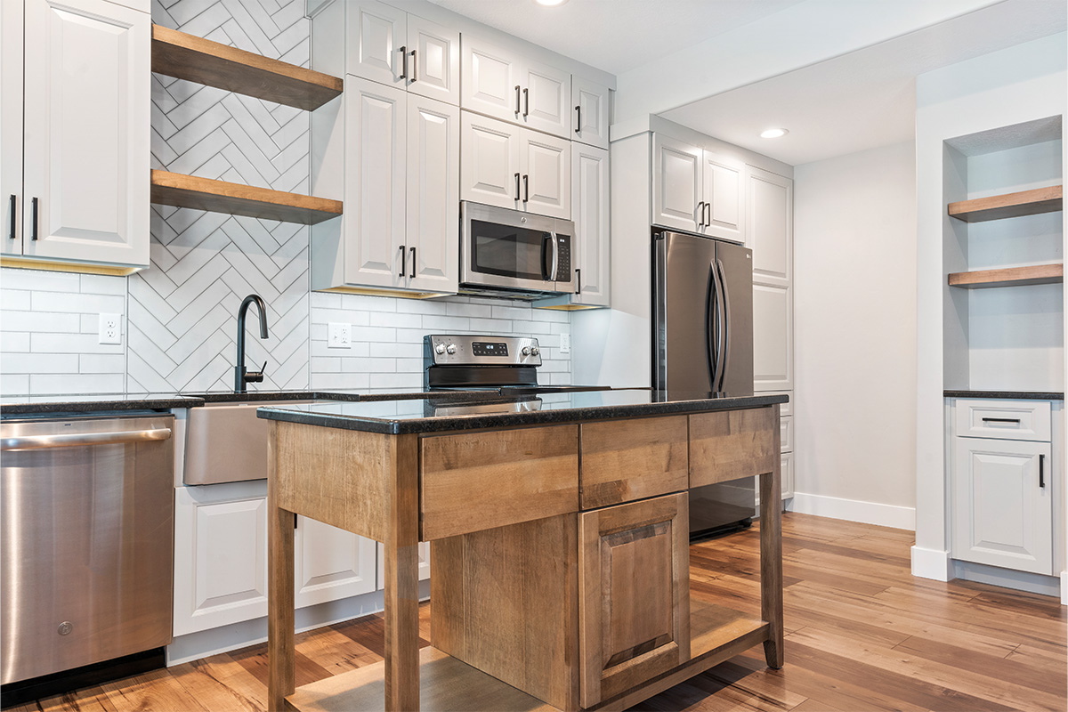 Painted Gun Smoke kitchen perimeter cabinets with a brown stained island cabinet.