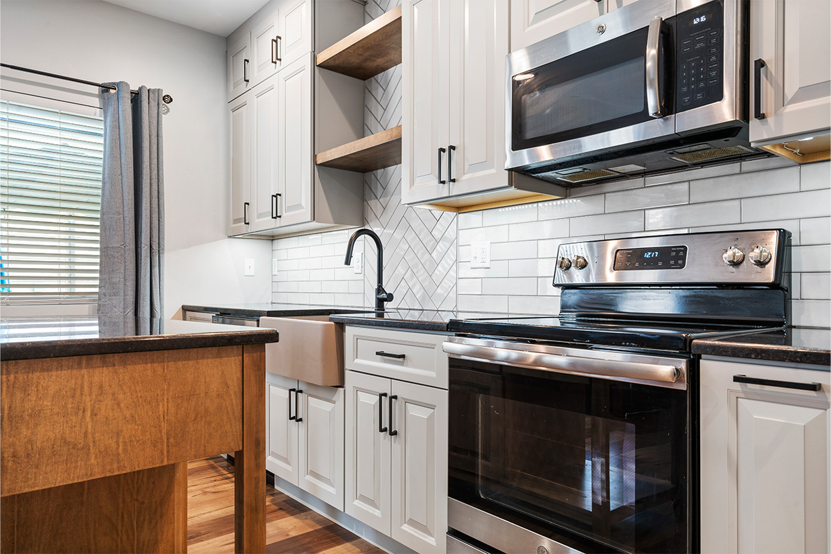 Painted Gun Smoke kitchen perimeter cabinets with a brown stained island cabinet.