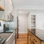 Painted Gun Smoke kitchen perimeter cabinets with a brown stained island cabinet.