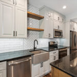 Painted Gun Smoke kitchen perimeter cabinets with a brown stained island cabinet.
