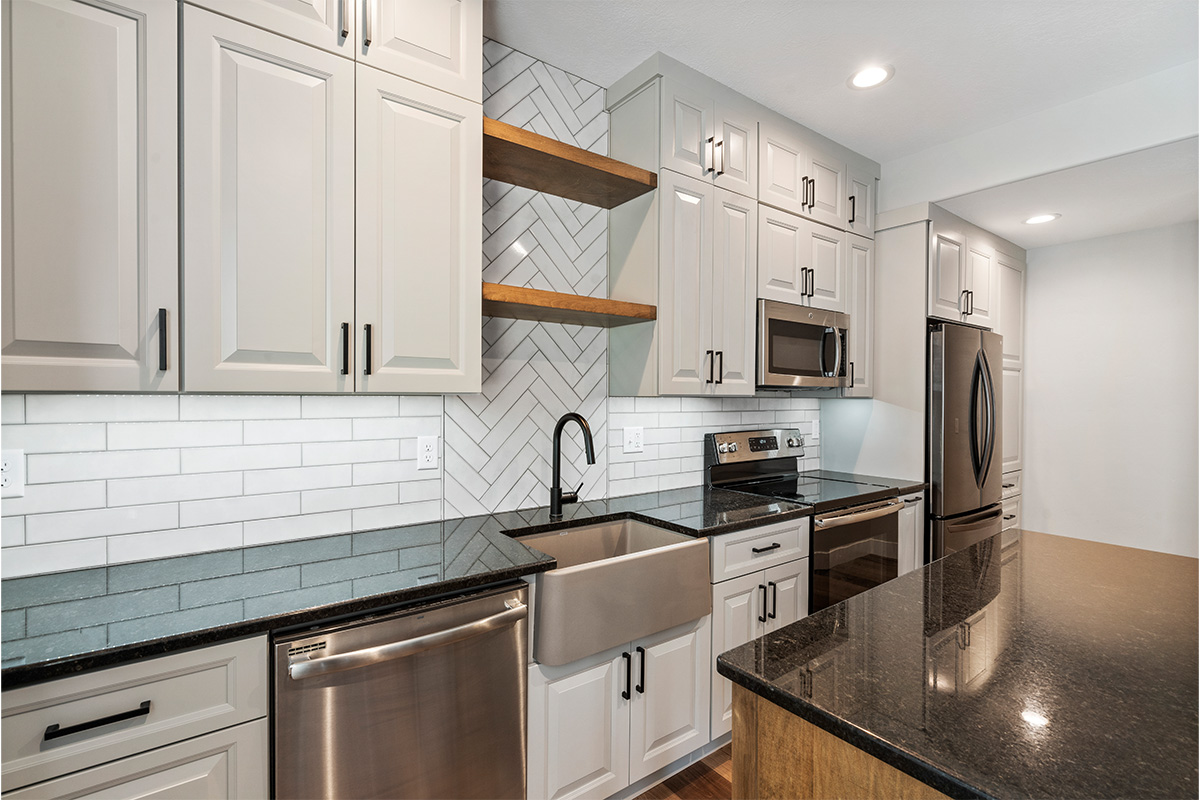 Painted Gun Smoke kitchen perimeter cabinets with a brown stained island cabinet.