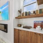 Walnut natural cabinet with floating shelf beside a fireplace
