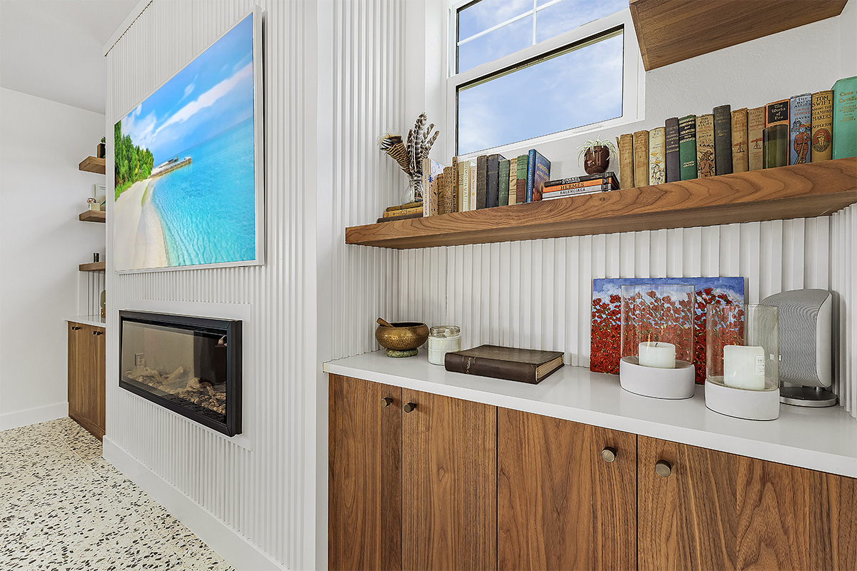 Walnut natural cabinet with floating shelf beside a fireplace