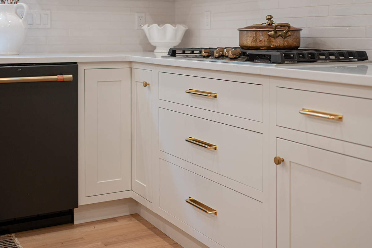 Kitchen with White perimeter cabinets and Quartersawn White Oak island cabinets stained in light brown Pampas finish.