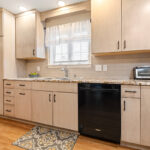 Light maple kitchen perimeter cabinets with red-stained island.