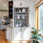 White kitchen storage cabinet that stores mixers and other appliances behind pocket doors
