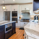 White kitchen with dark stained island and accents.