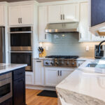 White kitchen with dark stained island and accents.