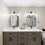 Gray bathroom vanity with 2 sinks and mirrors