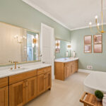 Light stained bathroom vanity cabinets and free standing tub