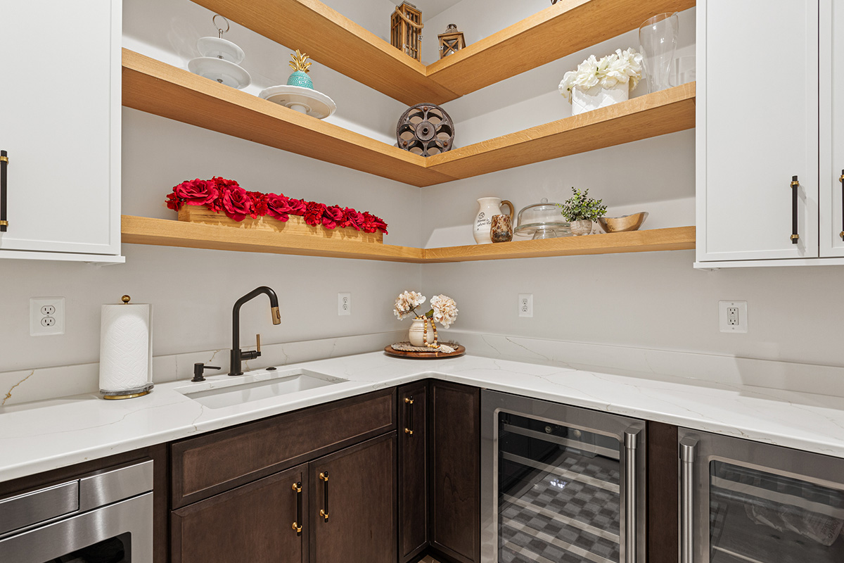 Prep kitchen with dark stained cabinets and natural floating shelves