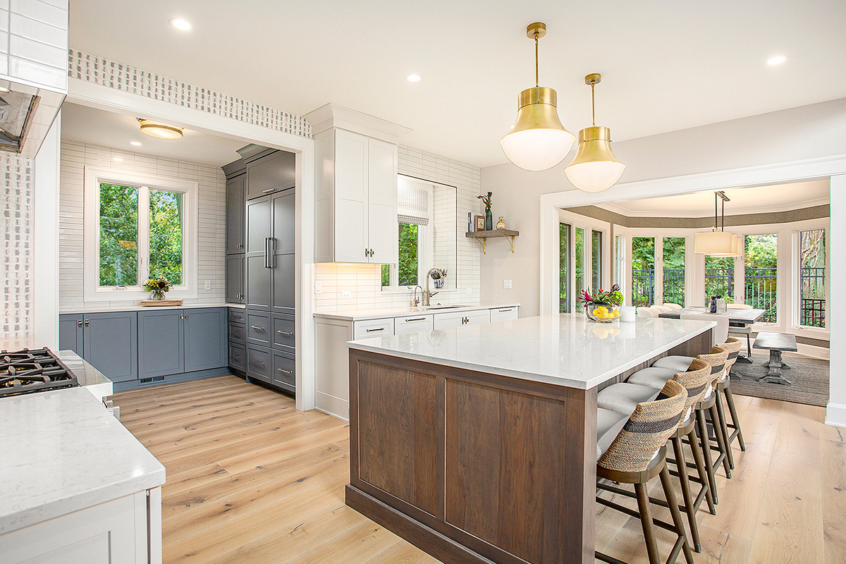 White kitchen cabinets with stained hickory island.