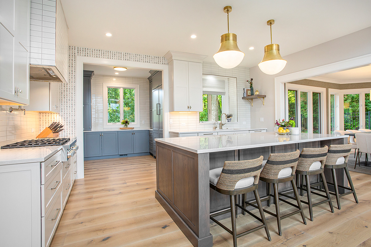 White kitchen cabinets with stained hickory island.