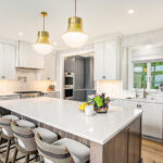 White kitchen cabinets with stained hickory island.